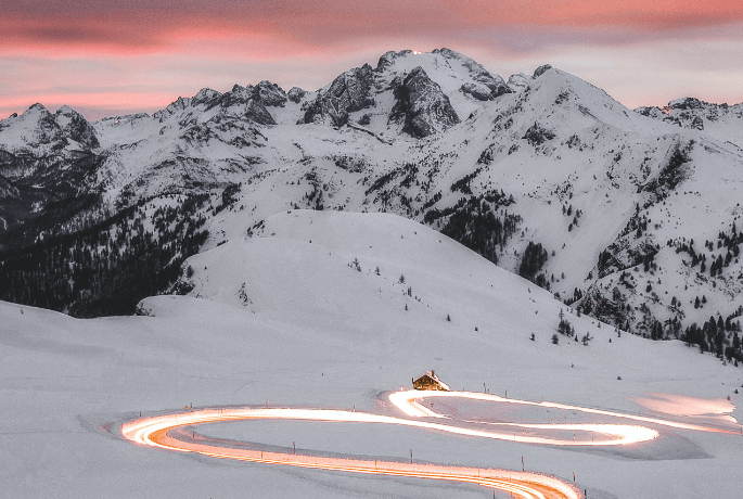 car driving up snowy mountain roads