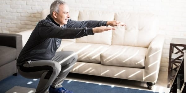 man doing a squat to improve ski fitness