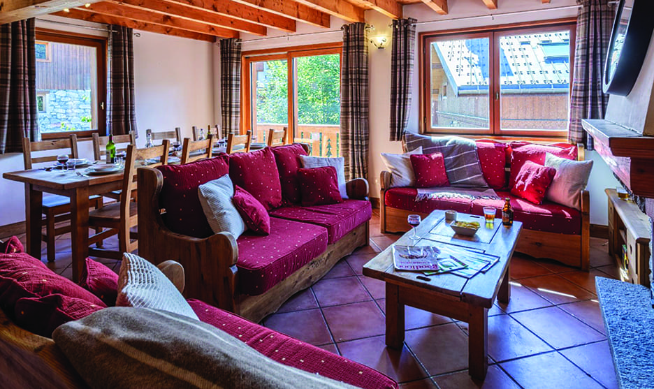 Chalet Lys Blanc lounge with red sofas and a dining table