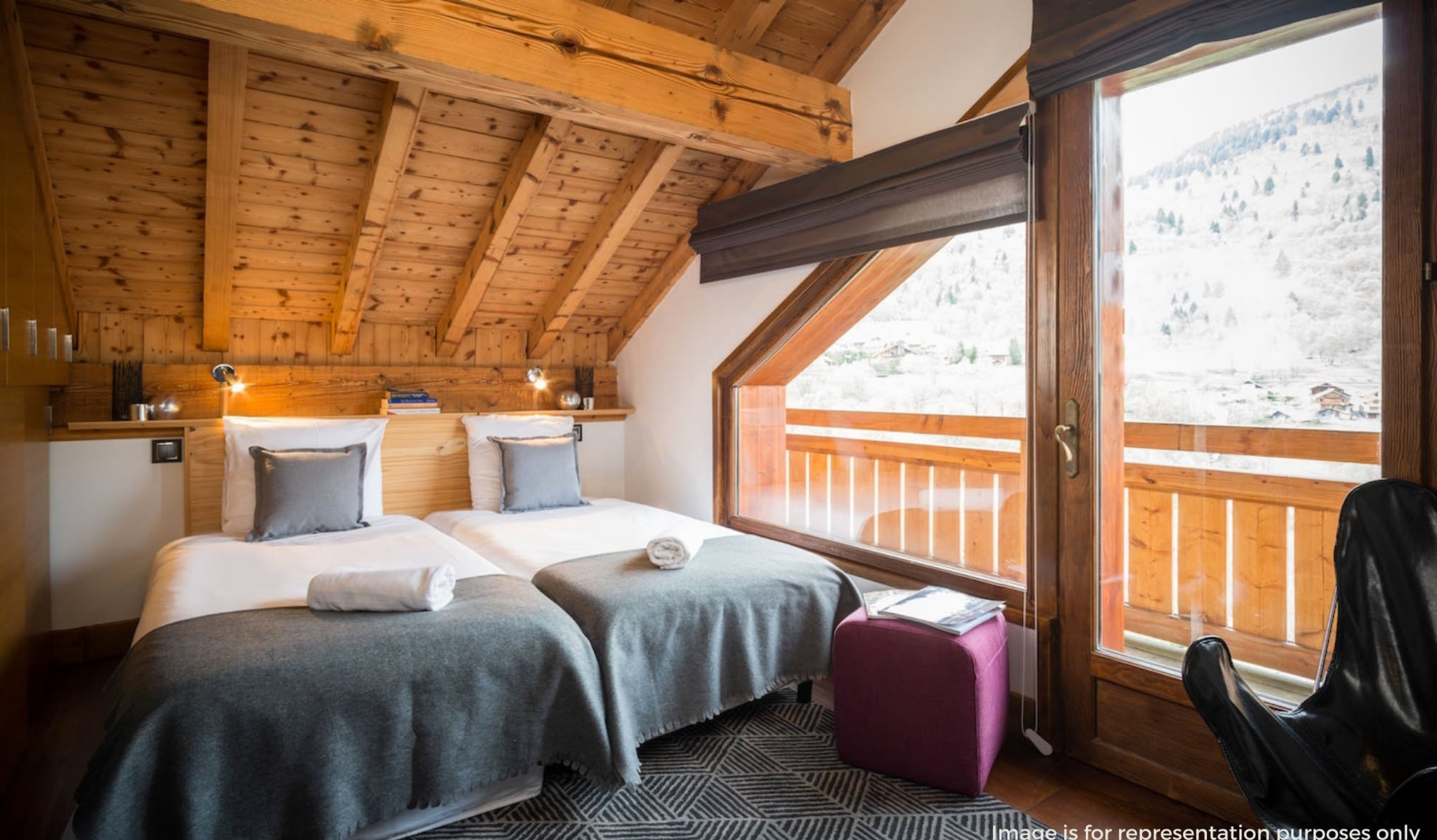 Twin bedroom with timber ceiling and a balcony view over the mountains